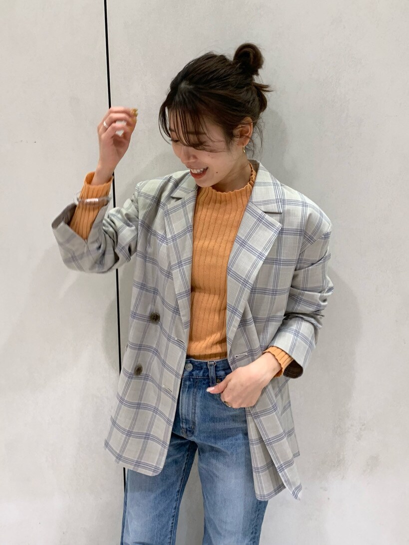 ブルー系のテーラードジャケット、ブルー系のデニムパンツ、オレンジ系のニット/セーターを着用したレディースの冬コーディネートの3枚目の写真