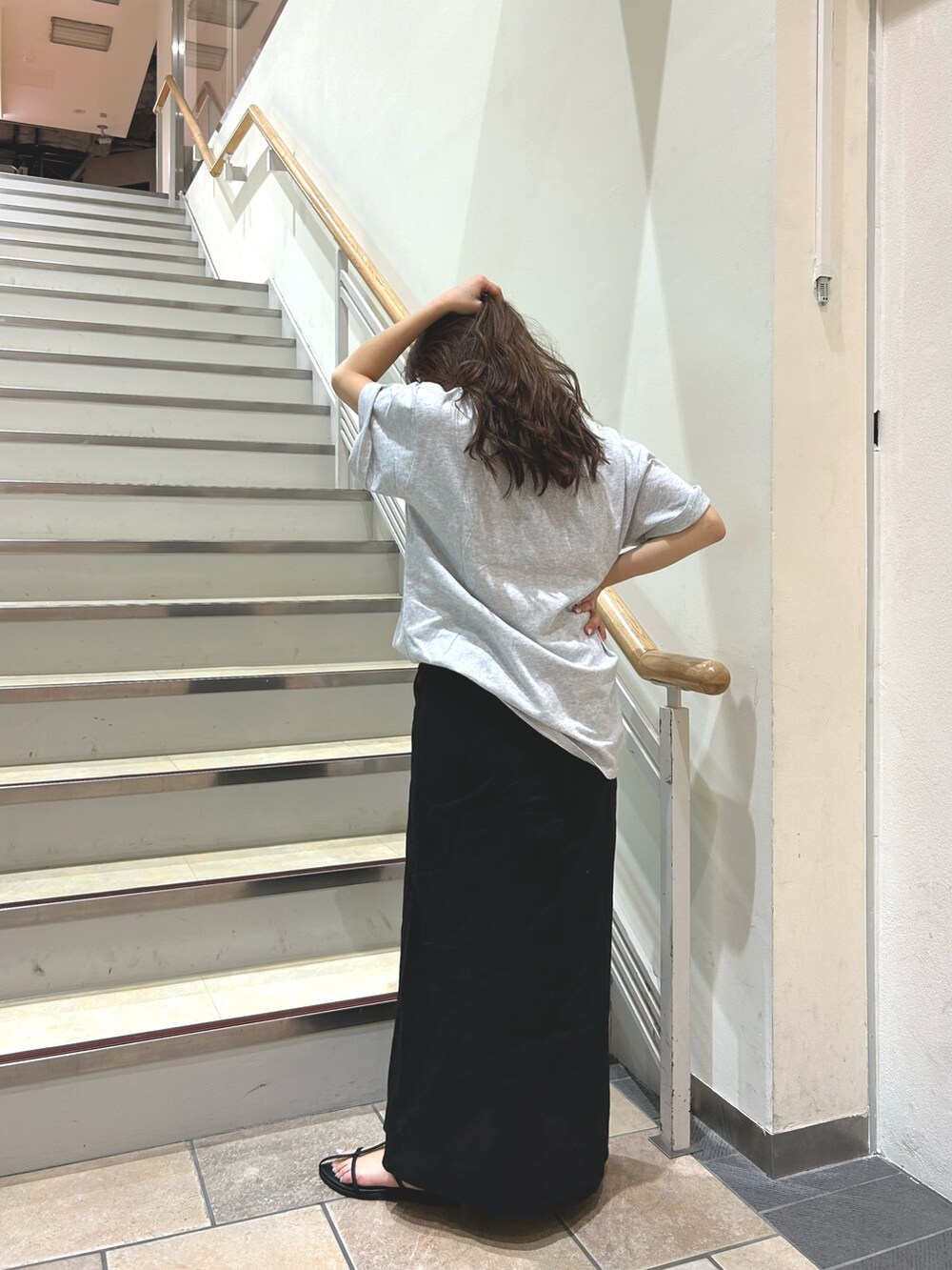 ブラック系のサンダル、グレー系のTシャツ/カットソー、ブラック系のスカートを着用したレディースの春コーディネートの3枚目の写真