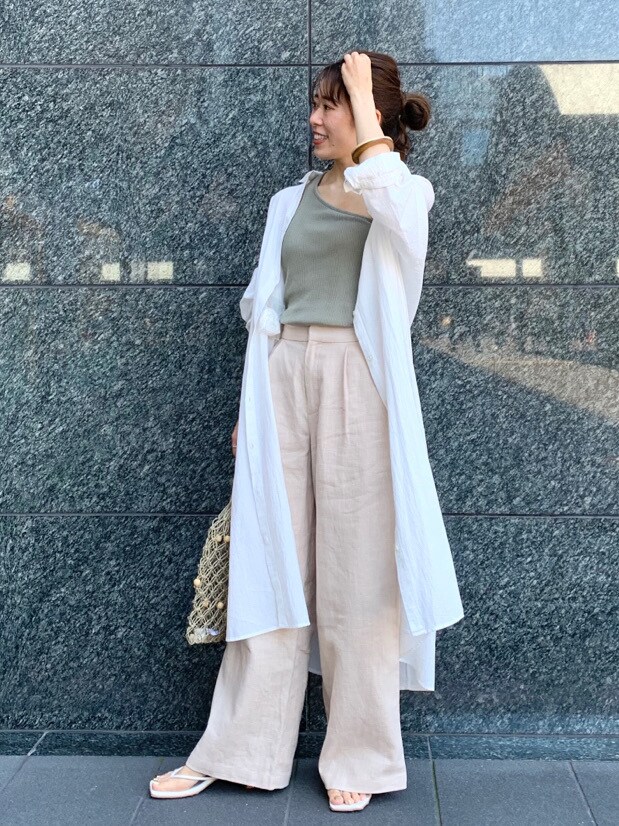 ホワイト系のサンダル、ベージュ系のハンドバッグ、ベージュ系のタンクトップを着用したレディースの夏コーディネートの2枚目の写真