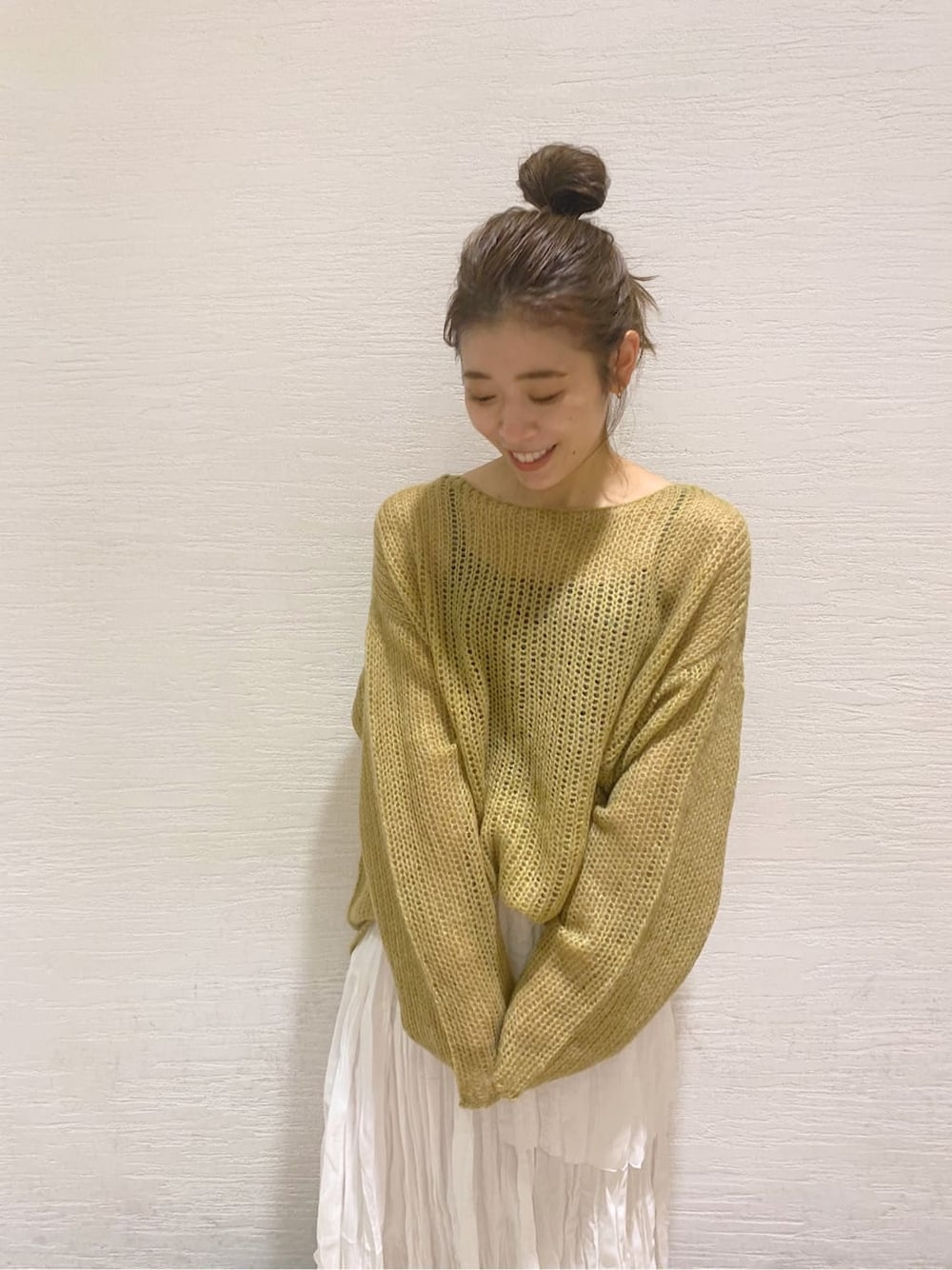 ホワイト系のスカート、ブラック系のブーツ、イエロー系のニット/セーターを着用したレディースの秋コーディネートの3枚目の写真