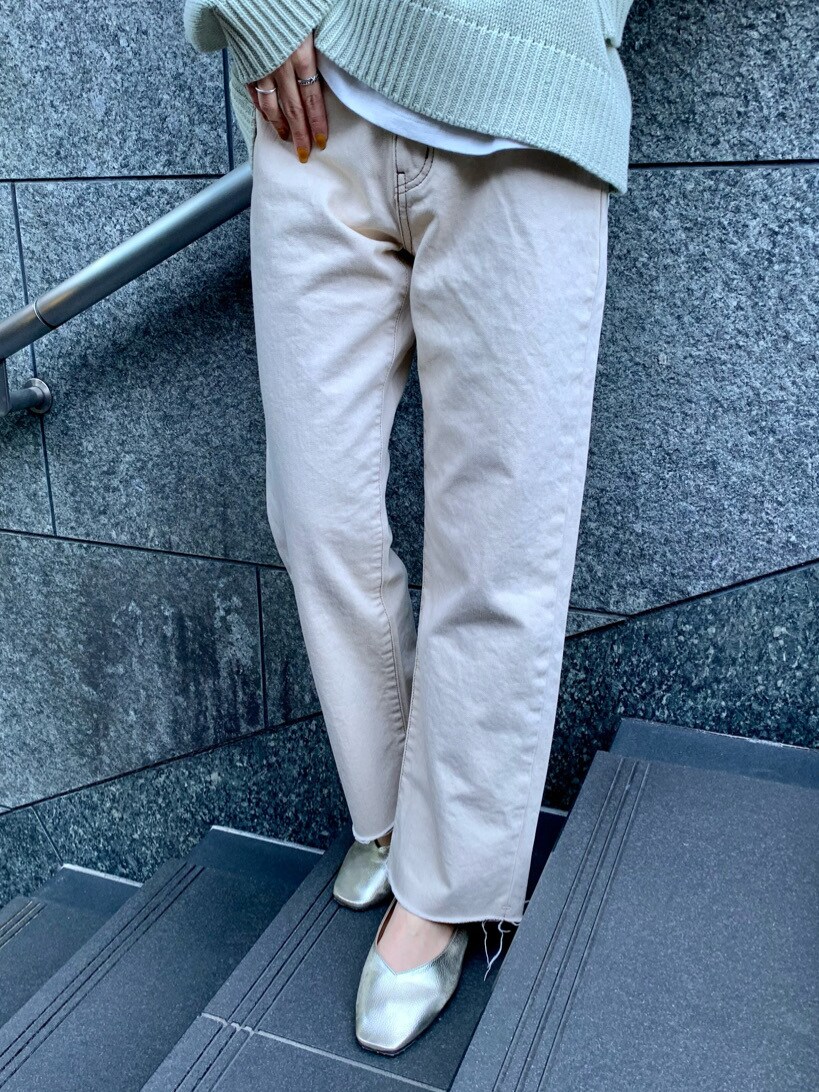 ホワイト系のデニムパンツ、ホワイト系のニット/セーター、ホワイト系のTシャツ/カットソーを着用したレディースの冬コーディネートの2枚目の写真