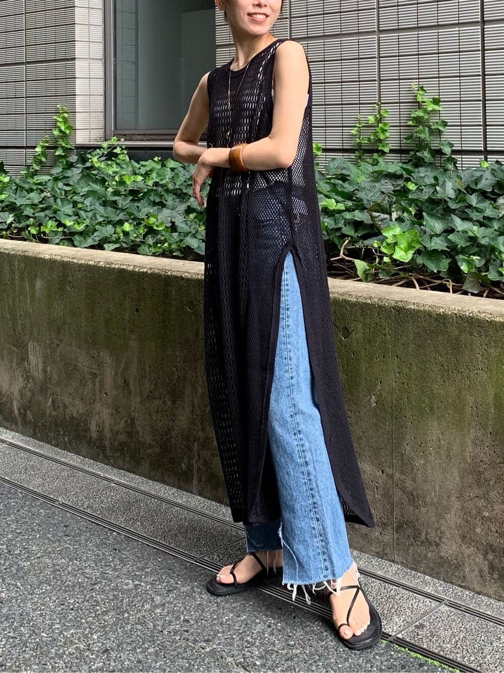 ブルー系のデニムパンツ、グレー系のワンピース、ブラック系のサンダルを着用したレディースの夏コーディネートの3枚目の写真