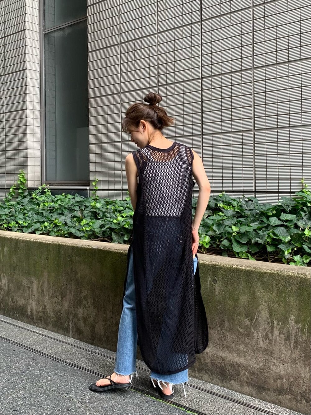 ブルー系のデニムパンツ、グレー系のワンピース、ブラック系のサンダルを着用したレディースの夏コーディネートの2枚目の写真