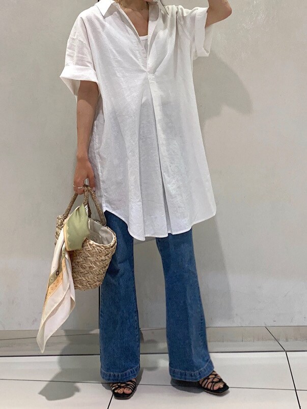 ホワイト系のシャツ/ブラウス、ブラック系のサンダル、ブルー系のデニムパンツを着用したレディースの夏コーディネートの2枚目の写真