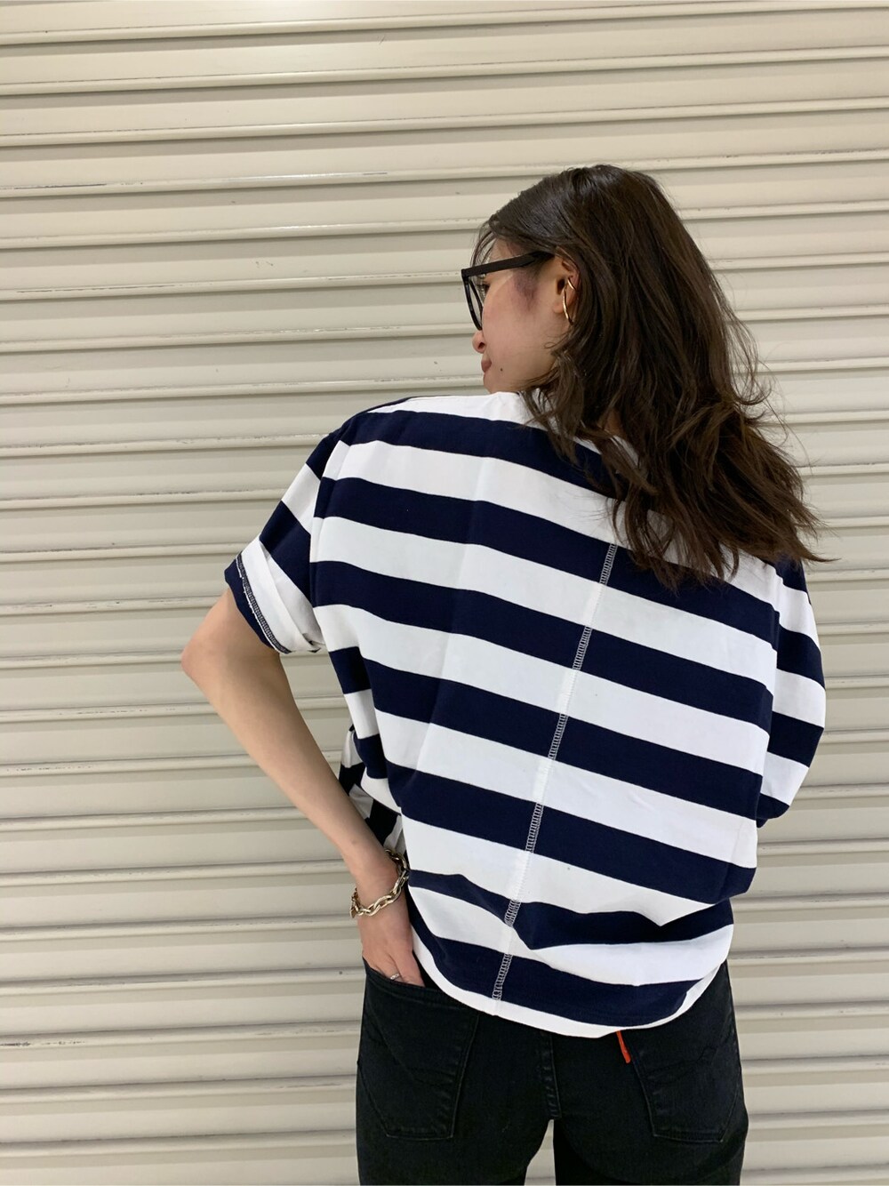 ブラック系のデニムパンツ、ブラック系のメガネを着用したレディースの春コーディネートの6枚目の写真