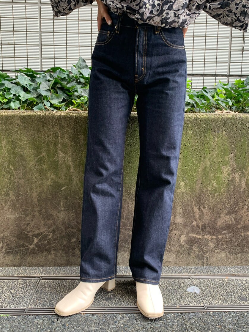 ブルー系のデニムパンツ、ブラウン系のトレンチコート、ブラック系のシャツ/ブラウスを着用したレディースの夏コーディネートの7枚目の写真