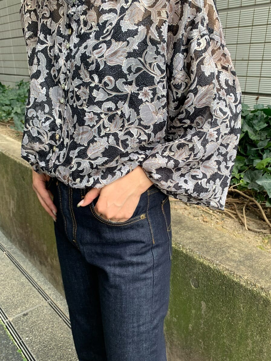 ブルー系のデニムパンツ、ブラウン系のトレンチコート、ブラック系のシャツ/ブラウスを着用したレディースの夏コーディネートの6枚目の写真