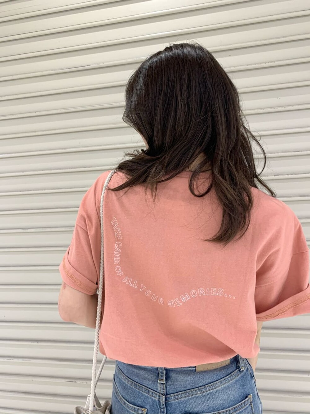 ホワイト系のハンドバッグ、ピンク系のTシャツ/カットソーを着用したレディースの夏コーディネートの2枚目の写真