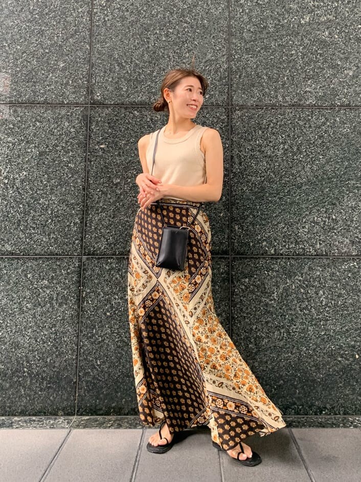 ブラック系のボディバッグ/ウエストポーチ、イエロー系のスカート、ブラック系のサンダルを着用したレディースの夏コーディネートの2枚目の写真