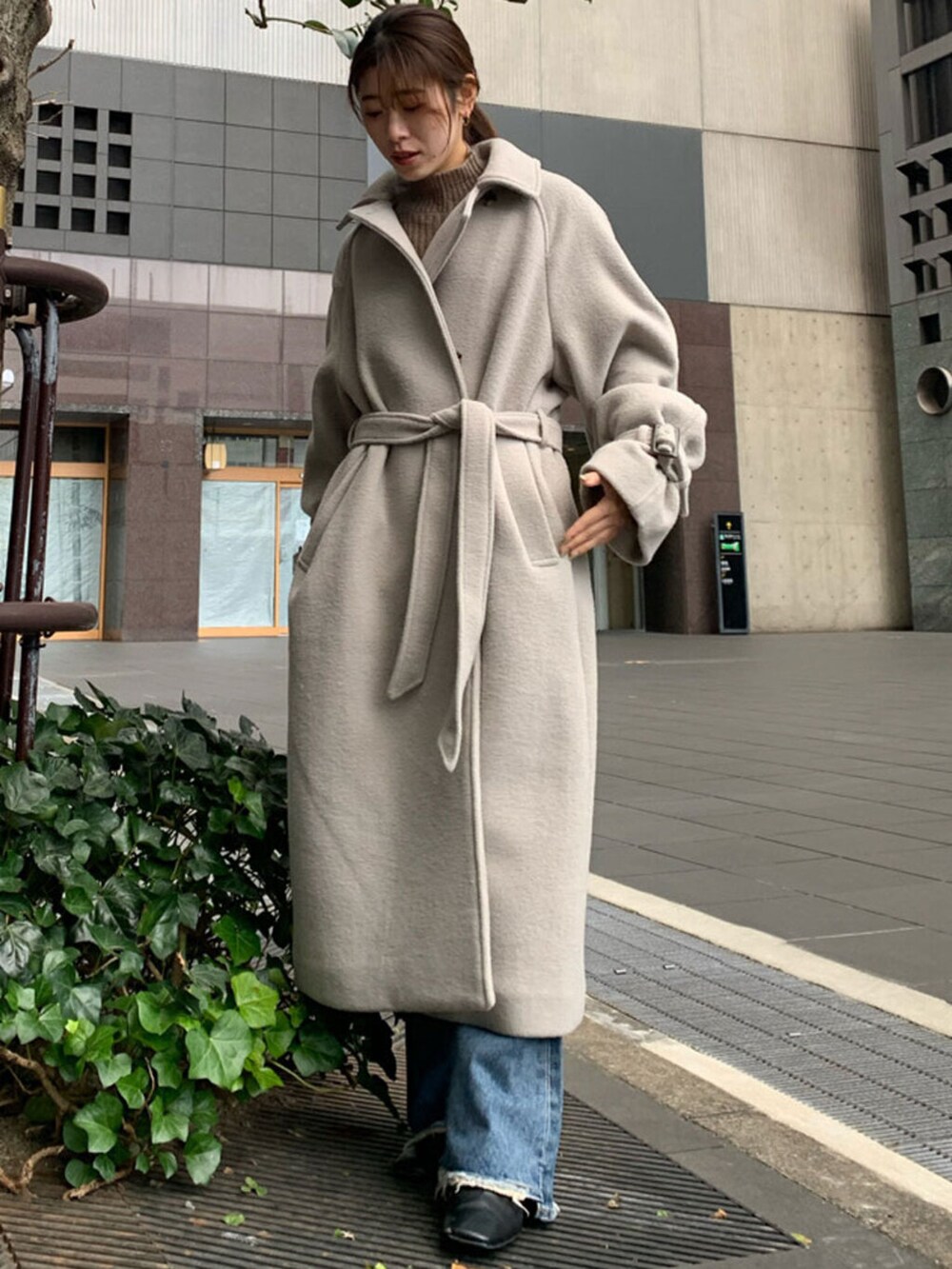 ブルー系のデニムパンツ、グレー系のステンカラーコートを着用したレディースの冬コーディネートの3枚目の写真