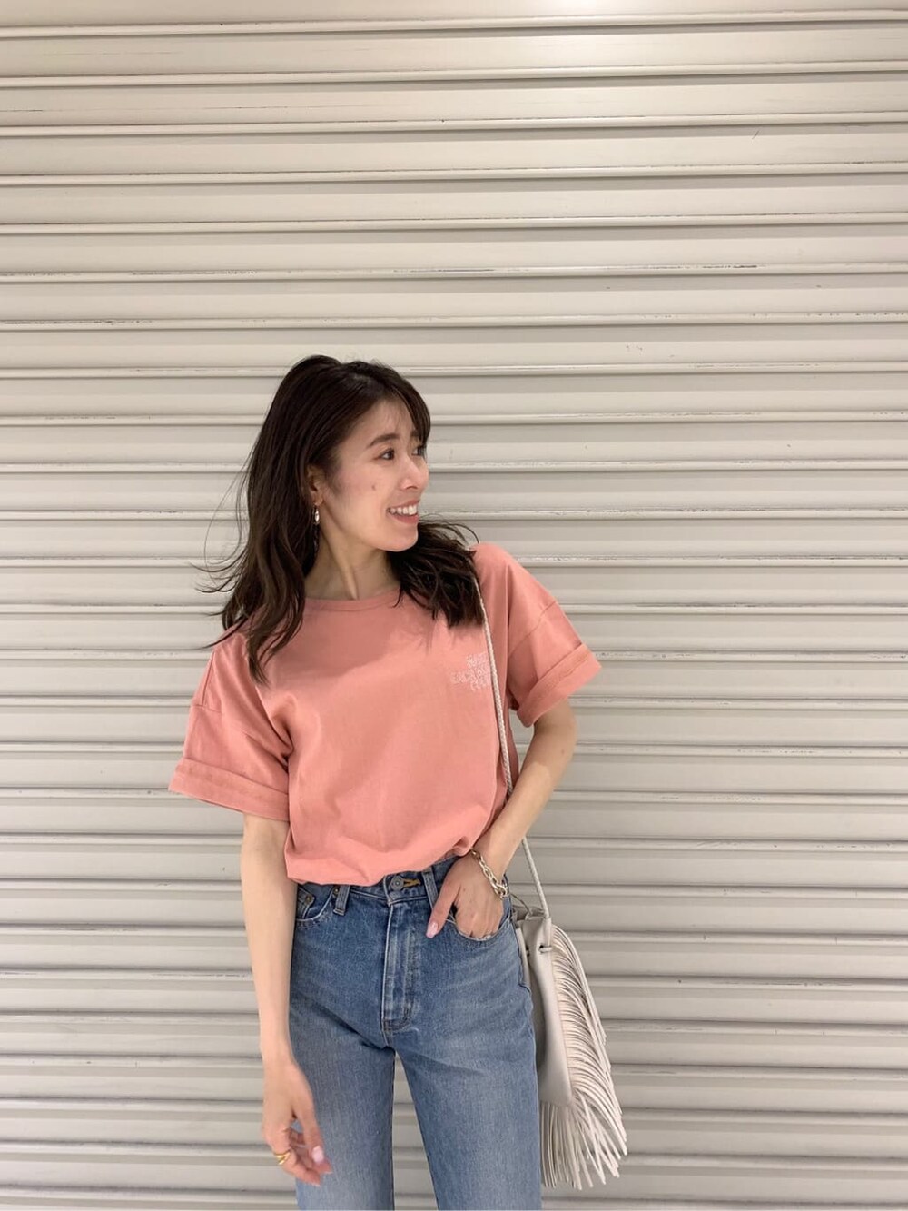 ホワイト系のハンドバッグ、ピンク系のTシャツ/カットソーを着用したレディースの夏コーディネートの3枚目の写真