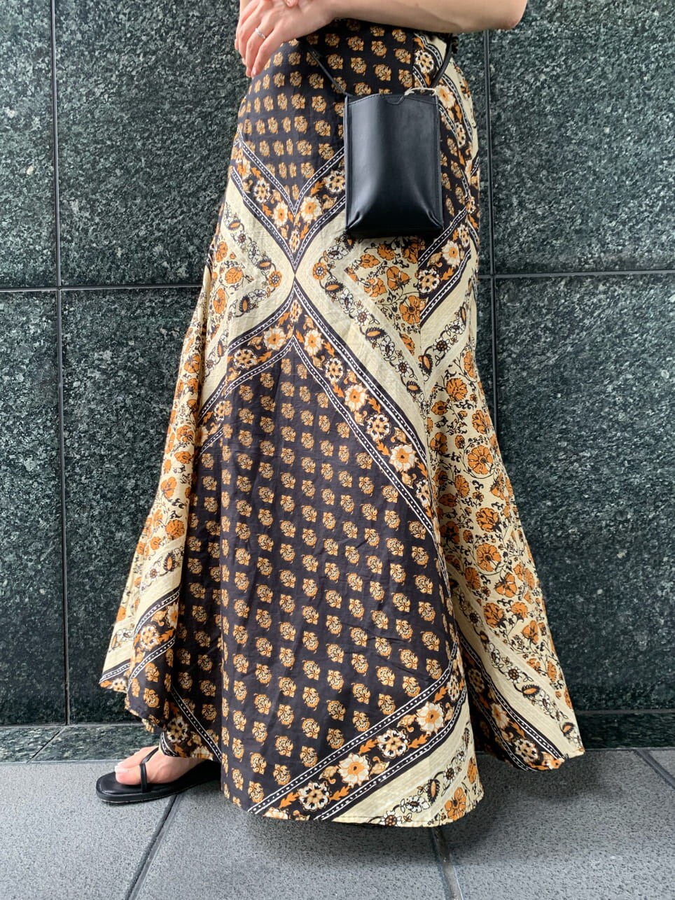 ブラック系のボディバッグ/ウエストポーチ、イエロー系のスカート、ブラック系のサンダルを着用したレディースの夏コーディネートの5枚目の写真