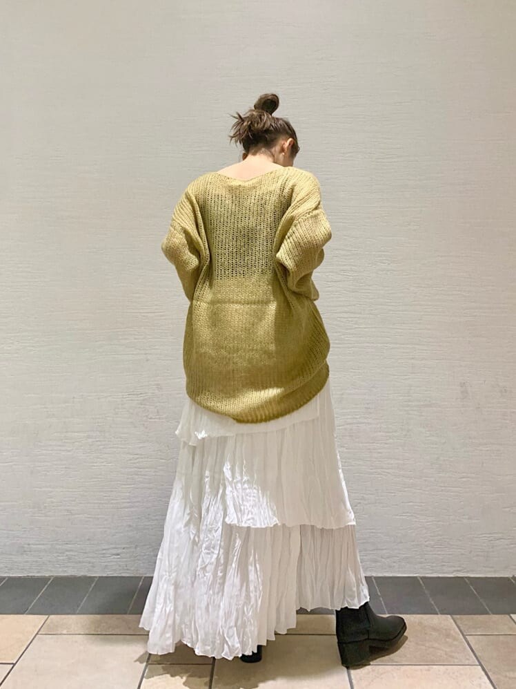 ホワイト系のスカート、ブラック系のブーツ、イエロー系のニット/セーターを着用したレディースの秋コーディネートの2枚目の写真