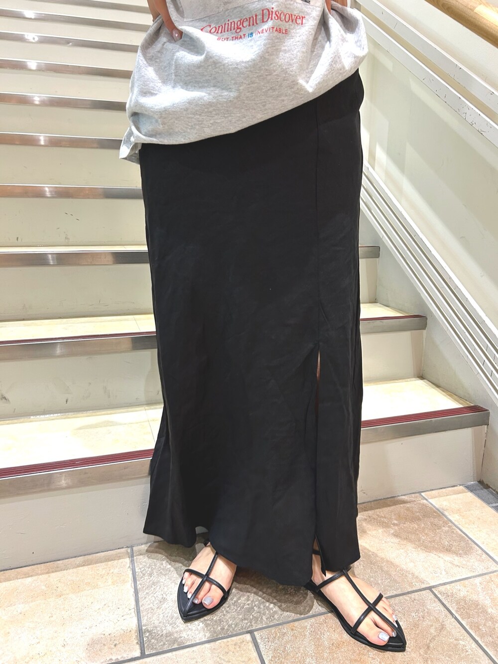 ブラック系のサンダル、グレー系のTシャツ/カットソー、ブラック系のスカートを着用したレディースの春コーディネートの4枚目の写真