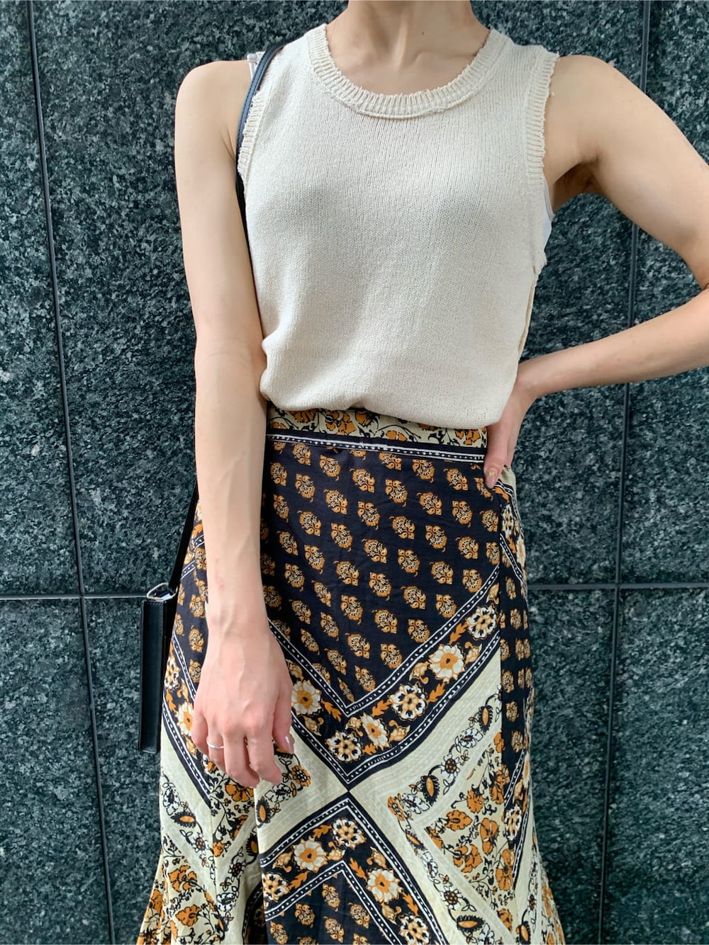 ブラック系のボディバッグ/ウエストポーチ、イエロー系のスカート、ブラック系のサンダルを着用したレディースの夏コーディネートの4枚目の写真