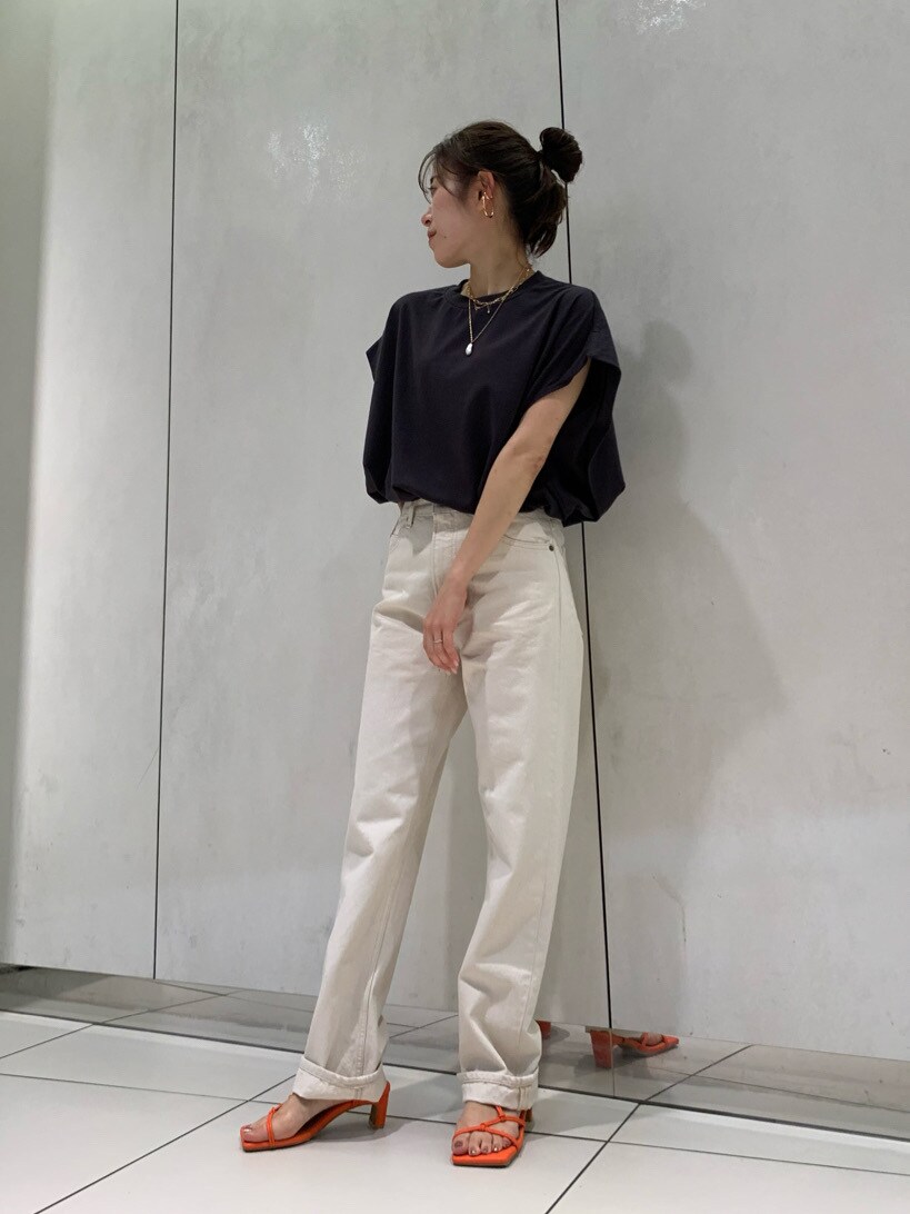 ホワイト系のデニムパンツ、ブラック系のTシャツ/カットソー、オレンジ系のサンダルを着用したレディースの春コーディネートの2枚目の写真