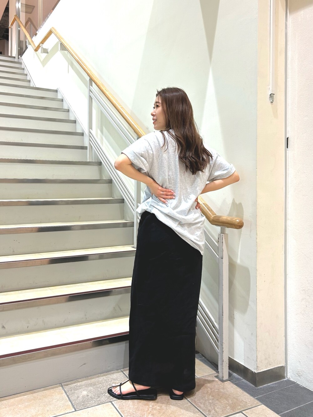 ブラック系のサンダル、グレー系のTシャツ/カットソー、ブラック系のスカートを着用したレディースの春コーディネートの2枚目の写真