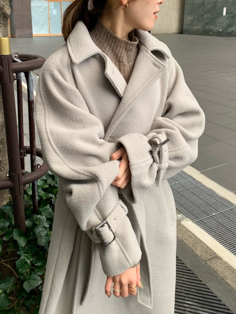 ブルー系のデニムパンツ、グレー系のステンカラーコートを着用したレディースの冬コーディネートの2枚目の写真