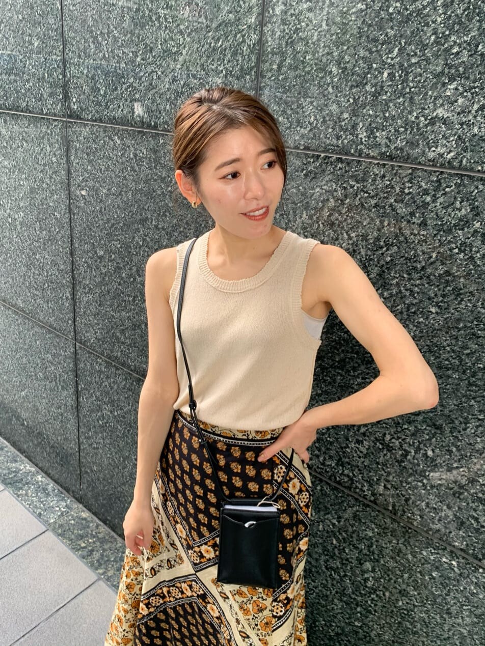 ブラック系のボディバッグ/ウエストポーチ、イエロー系のスカート、ブラック系のサンダルを着用したレディースの夏コーディネートの6枚目の写真