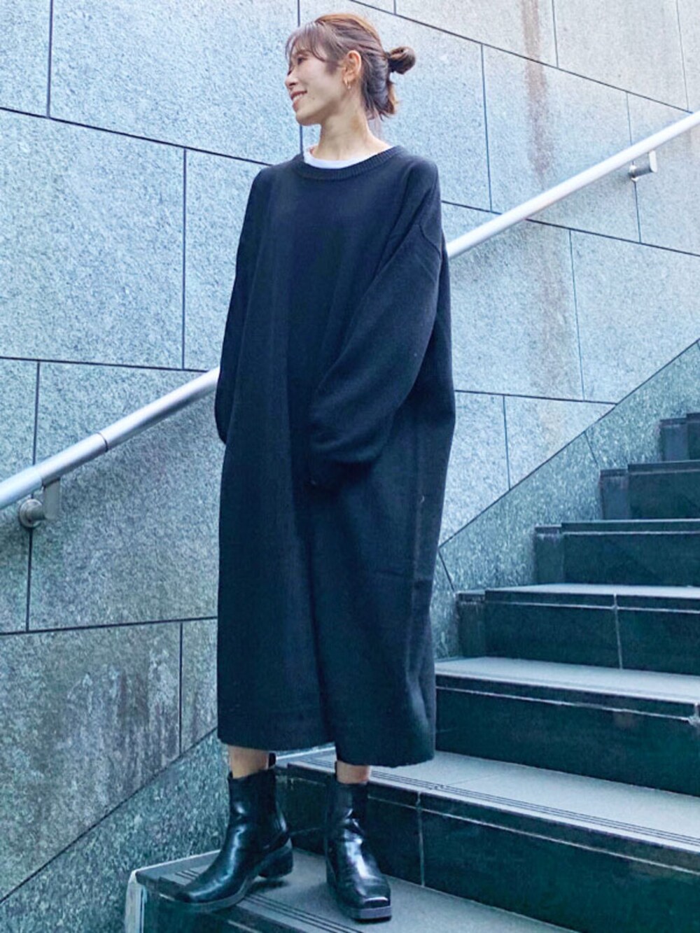 ブラック系のブーツ、ベージュ系のノーカラーコート、ブラック系のワンピースを着用したレディースの秋コーディネートの2枚目の写真