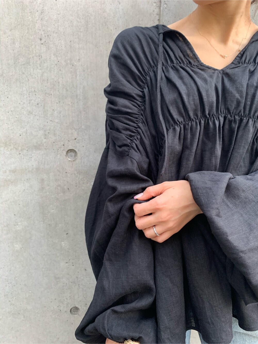 ブラック系のシャツ/ブラウス、ベージュ系のかごバッグ、ブルー系のデニムパンツを着用したレディースの春コーディネートの6枚目の写真