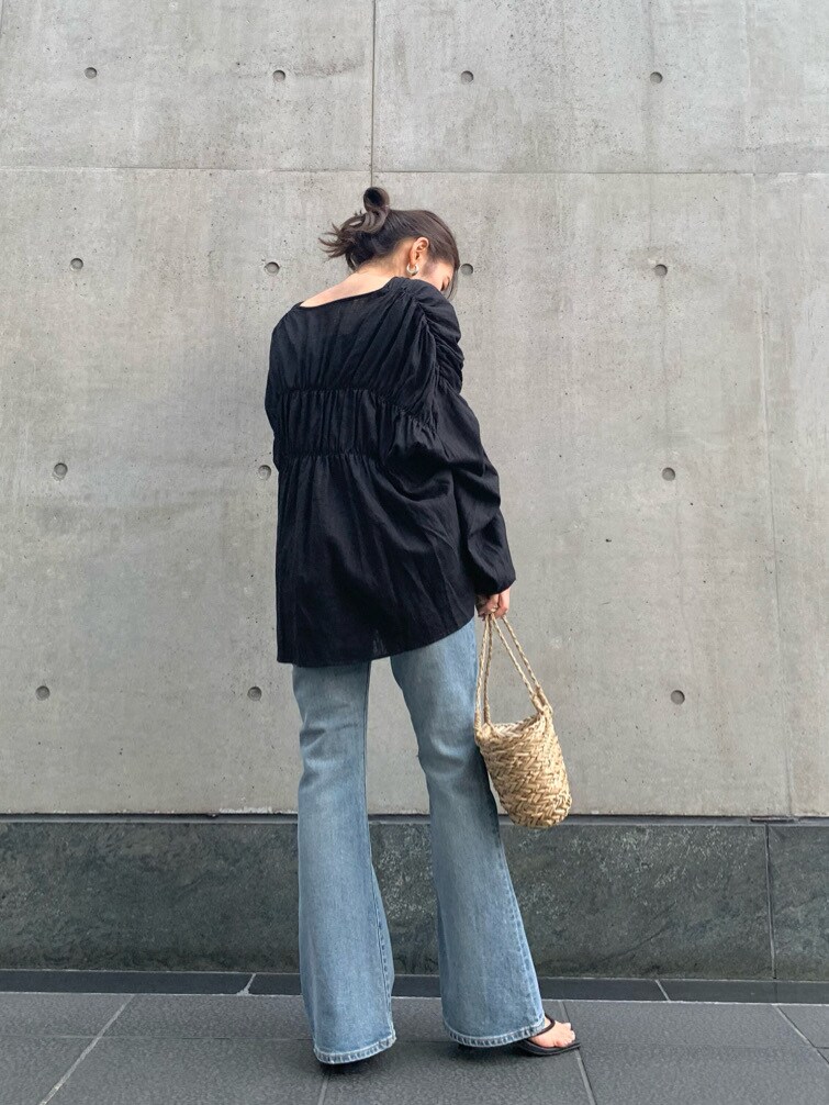 ブラック系のシャツ/ブラウス、ベージュ系のかごバッグ、ブルー系のデニムパンツを着用したレディースの春コーディネートの4枚目の写真