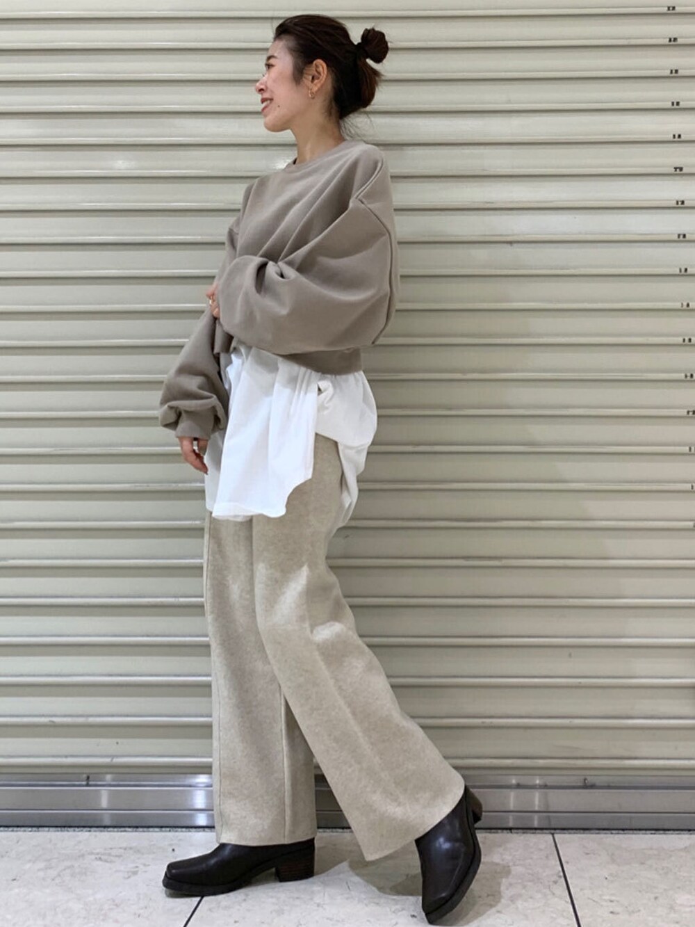 ブラック系のブーツ、ホワイト系のその他パンツを着用したレディースの冬コーディネートの3枚目の写真