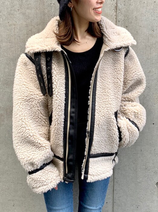 ブラック系のニット/セーター、ブラック系のブーツ、ブルー系のデニムパンツを着用したレディースの秋コーディネートの2枚目の写真