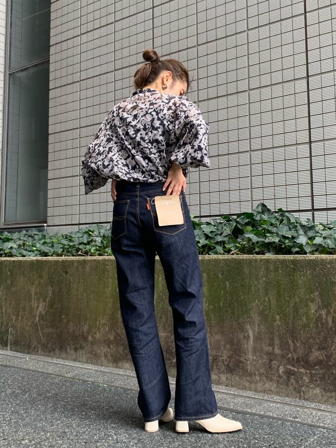 ブルー系のデニムパンツ、ブラウン系のトレンチコート、ブラック系のシャツ/ブラウスを着用したレディースの夏コーディネートの4枚目の写真