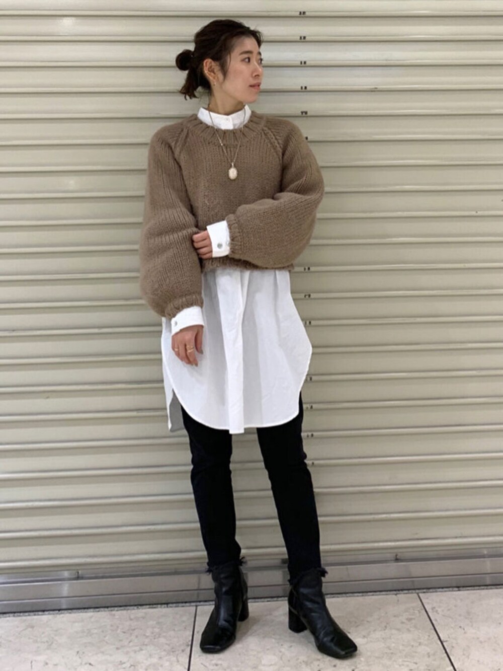 ブラック系のデニムパンツ、ベージュ系のニット/セーターを着用したレディースの冬コーディネートの2枚目の写真