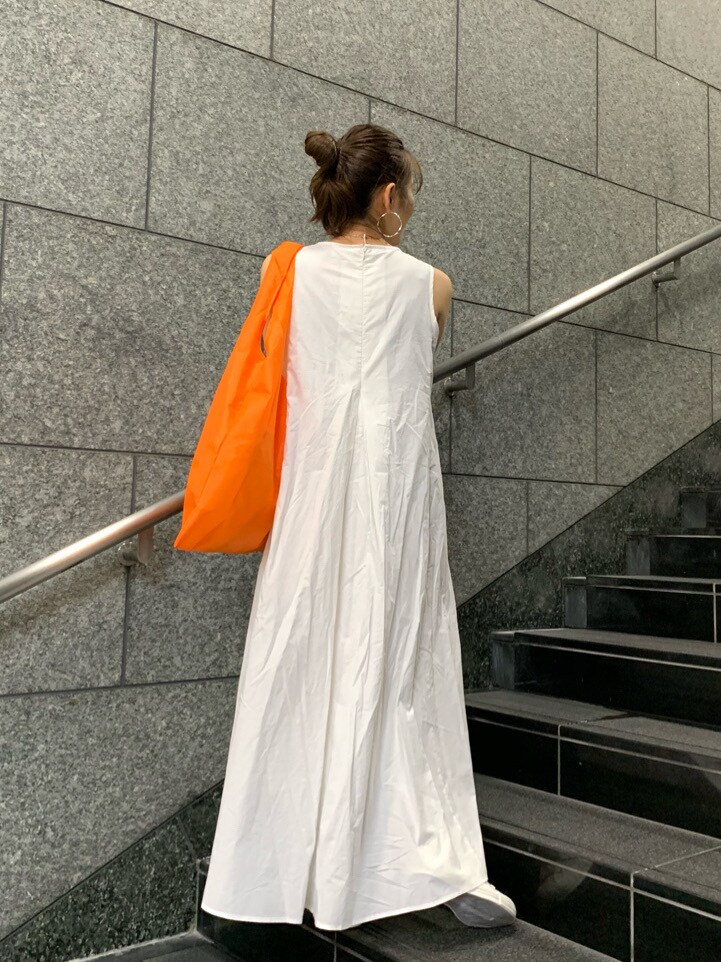 オレンジ系のハンドバッグ、ホワイト系のワンピースを着用したレディースの春コーディネートの4枚目の写真