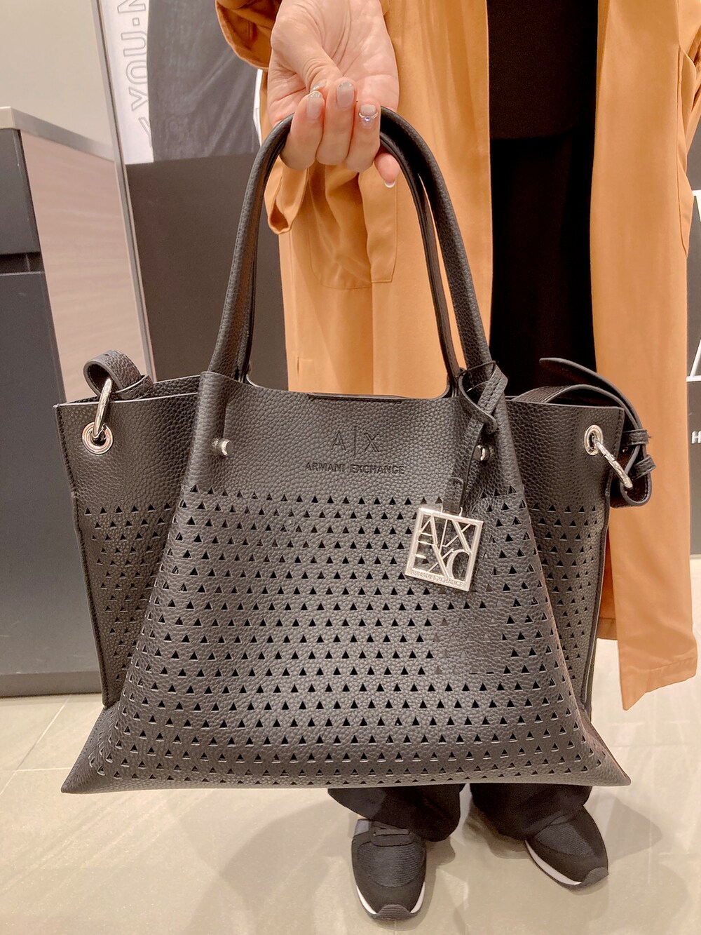 「AXchanger、AXchange、ARMANIEXCHANGE、アルマーニエクスチェンジ、キレイめ、高身長コーデ、PTA、お呼ばれスタイル、トートバッグ、トレンチコート、大人コーデ、差し色、ガウン、ワイドパンツ、高身長女子」|「ARMANI EXCHANGEの【A|X アルマーニ エクスチェンジ】パンチングデザイン ハンドバッグ(ハンドバッグ、ブラック系)」を使った、Iku.Yさん(レディース・168cm)の春コーディネートの2枚目の写真