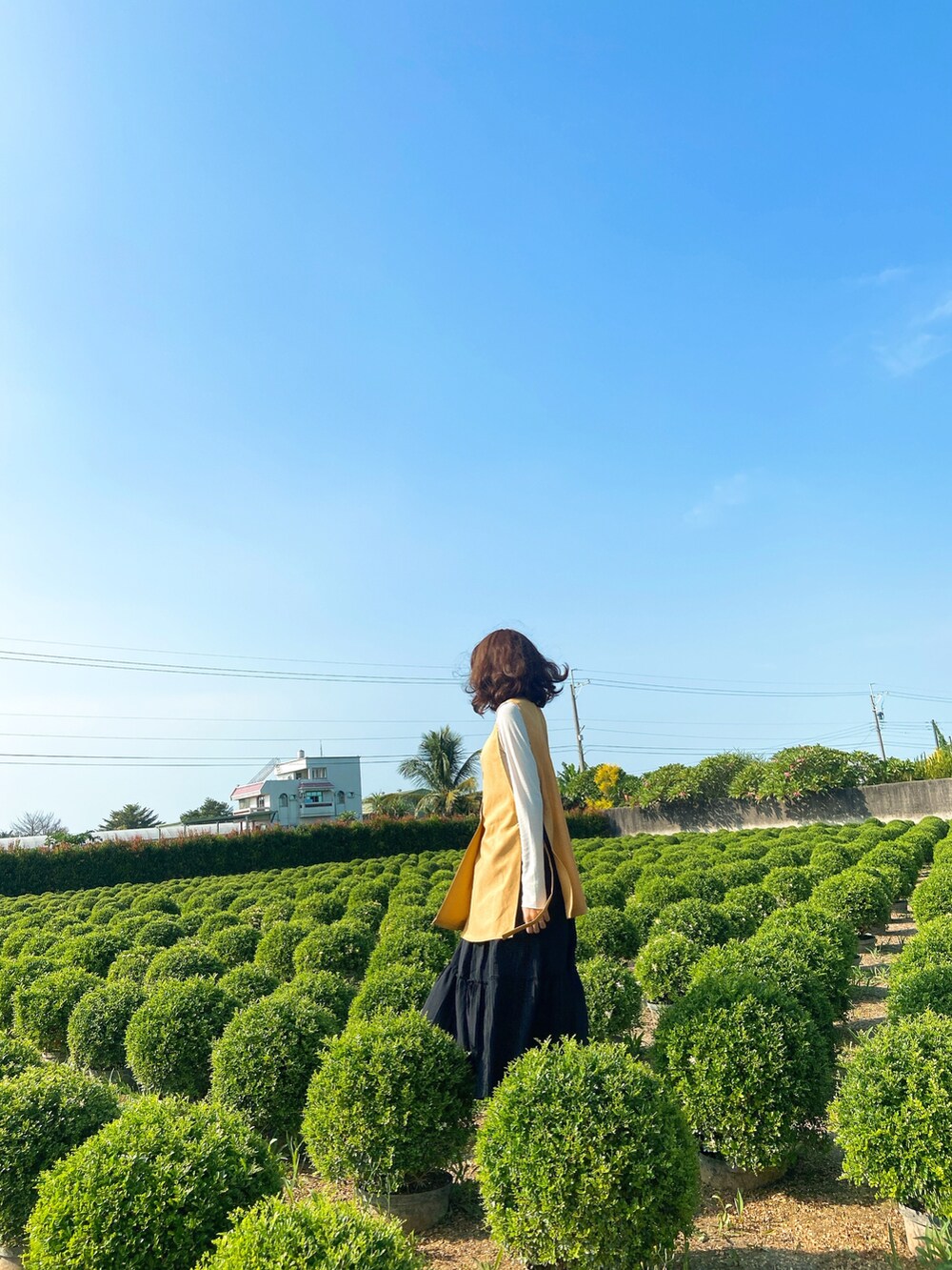 イエロー系のベストを着用したレディースの秋コーディネートの3枚目の写真