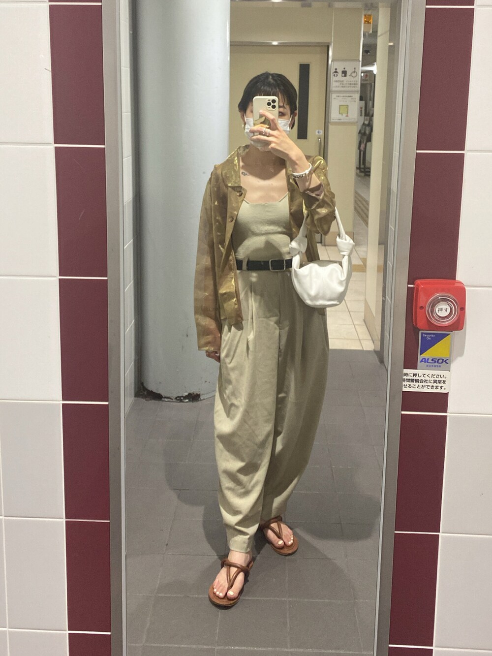 ゴールド系のシャツ/ブラウス、ホワイト系のトートバッグ、ブラウン系のサンダルを着用したレディースの夏コーディネートの2枚目の写真