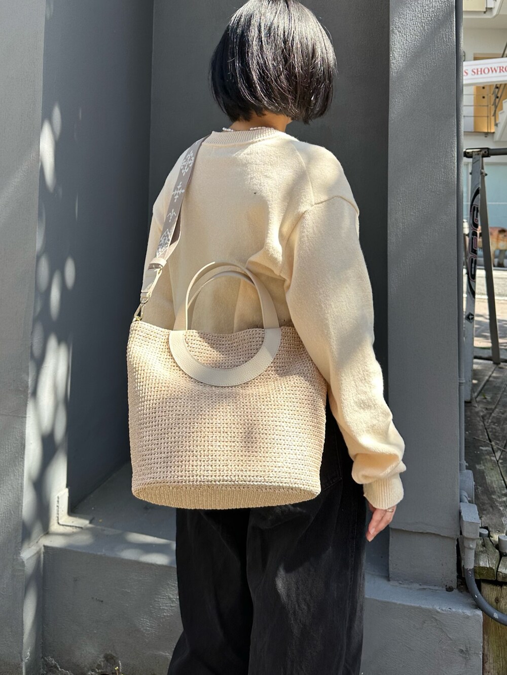 ホワイト系のトートバッグ、ホワイト系のカーディガン/ボレロを着用したレディースの春コーディネートの3枚目の写真