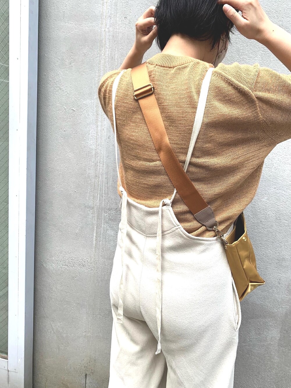 ホワイト系のサロペット/オーバーオール、ブラック系のスニーカー、イエロー系のトートバッグを着用したレディースの夏コーディネートの3枚目の写真