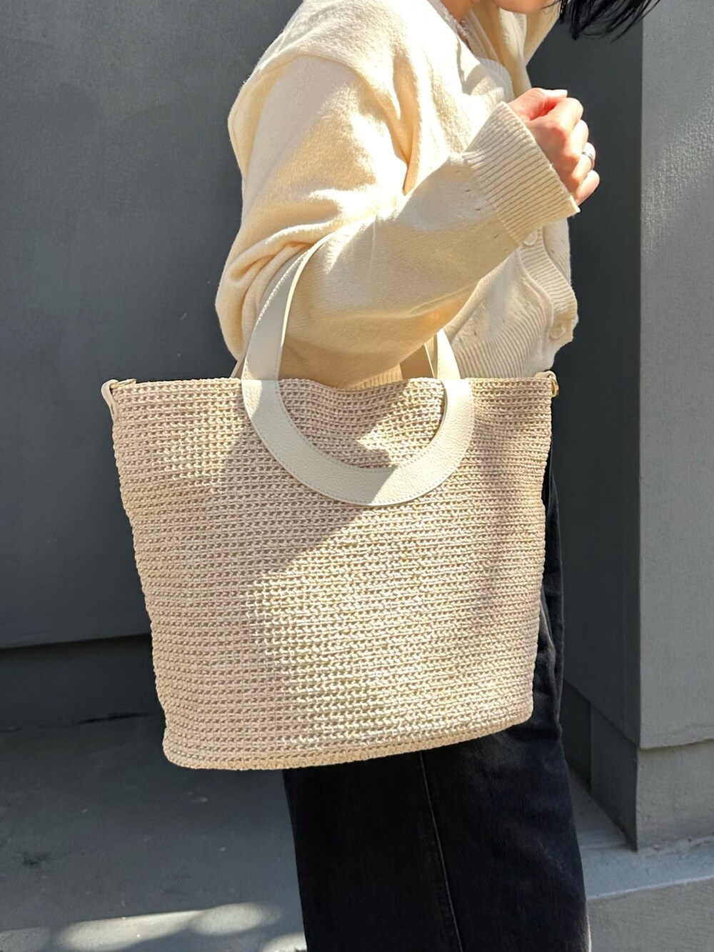 ホワイト系のトートバッグ、ホワイト系のカーディガン/ボレロを着用したレディースの春コーディネートの5枚目の写真