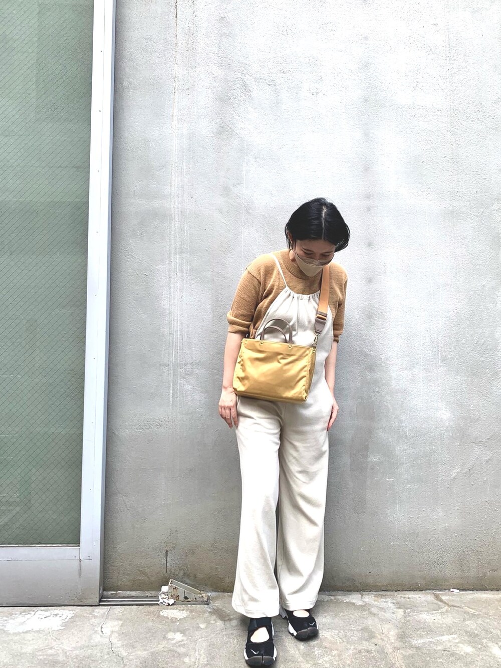 ホワイト系のサロペット/オーバーオール、ブラック系のスニーカー、イエロー系のトートバッグを着用したレディースの夏コーディネートの2枚目の写真