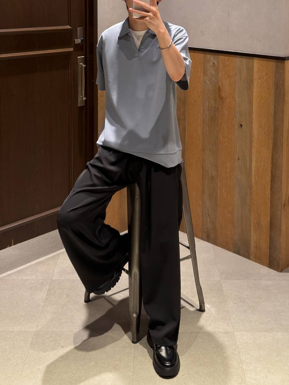 ブラック系のスラックス、ブラック系のドレスシューズ、ホワイト系のTシャツ/カットソーを着用したメンズの夏コーディネートの2枚目の写真