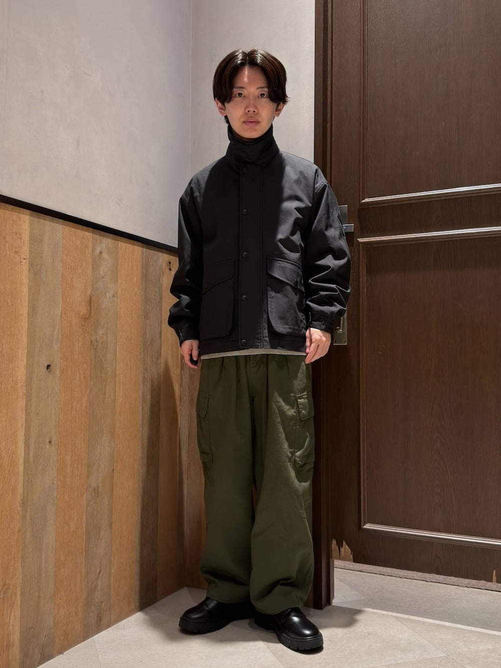 ブラック系のドレスシューズ、グリーン系のカーゴパンツ、グレー系のニット/セーターを着用したメンズの春コーディネートの3枚目の写真