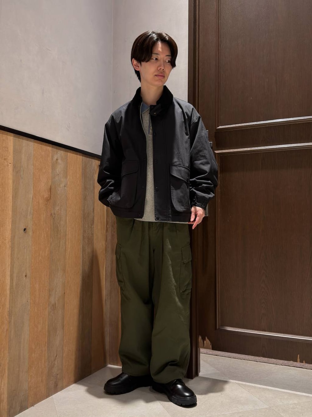 ブラック系のドレスシューズ、グリーン系のカーゴパンツ、グレー系のニット/セーターを着用したメンズの春コーディネートの2枚目の写真