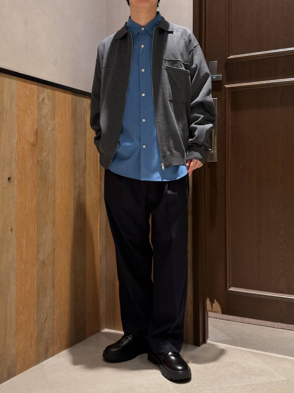 ブルー系のスラックス、ブラック系のドレスシューズ、ブルー系のシャツ/ブラウスを着用したメンズの春コーディネートの2枚目の写真