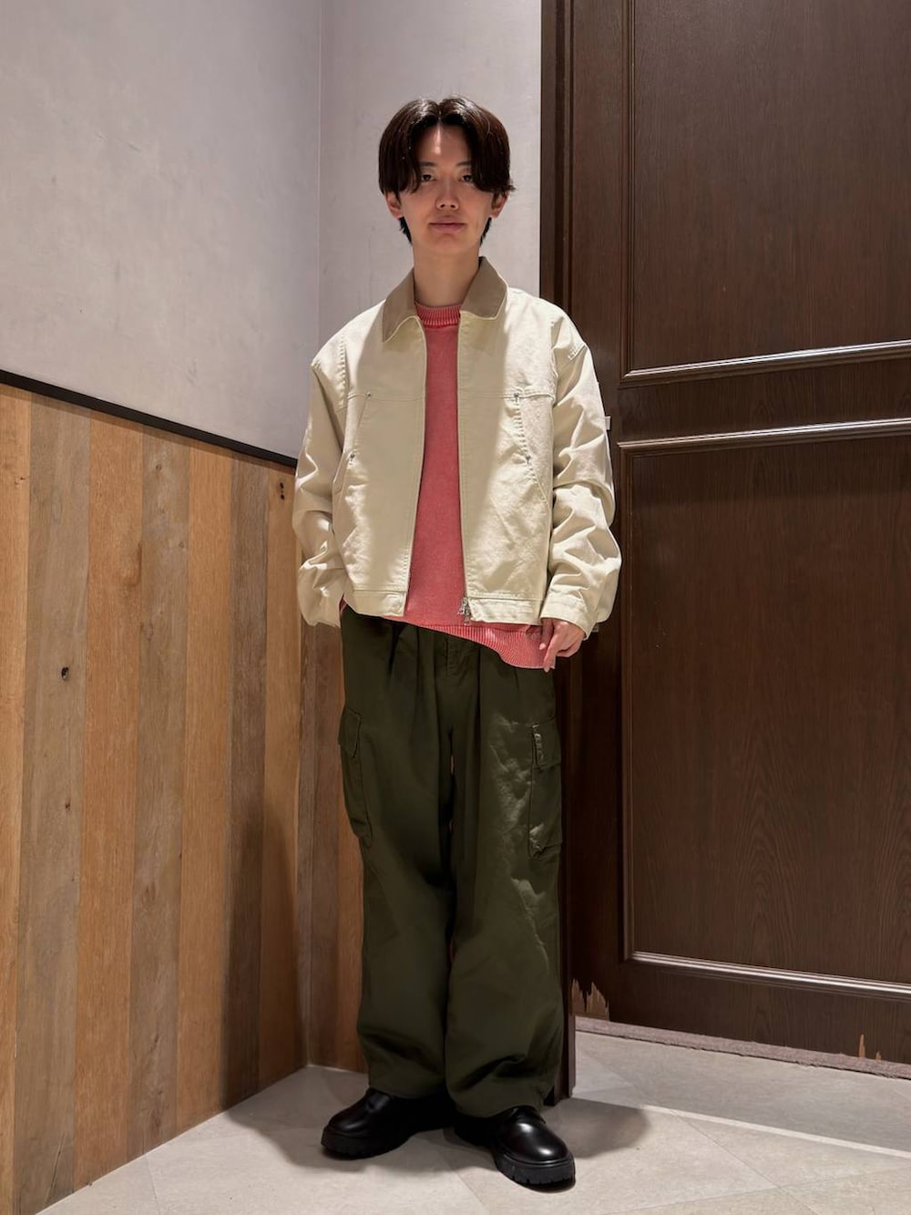 ブラック系のドレスシューズ、グリーン系のカーゴパンツ、ピンク系のニット/セーターを着用したメンズの春コーディネートの3枚目の写真