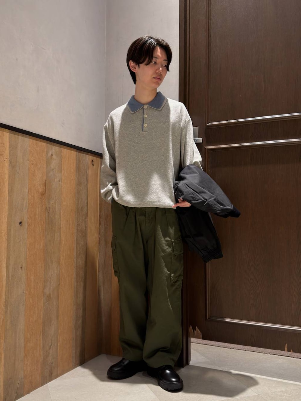 ブラック系のドレスシューズ、グリーン系のカーゴパンツ、グレー系のニット/セーターを着用したメンズの春コーディネートの5枚目の写真