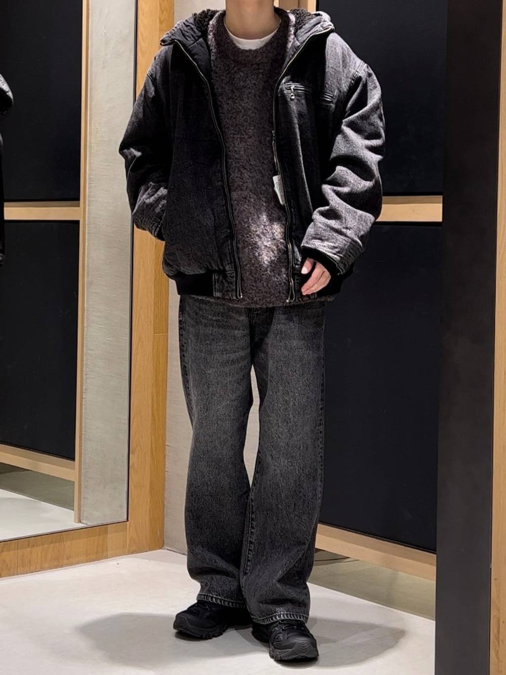 グレー系のブルゾン、ブラウン系のニット/セーター、グレー系のデニムパンツを着用したメンズの冬コーディネートの2枚目の写真