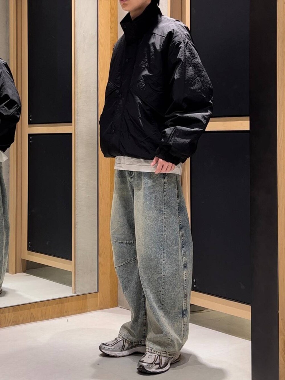 ブラック系のナイロンジャケット、ホワイト系のTシャツ/カットソー、ブルー系のデニムパンツを着用したメンズの秋コーディネートの2枚目の写真