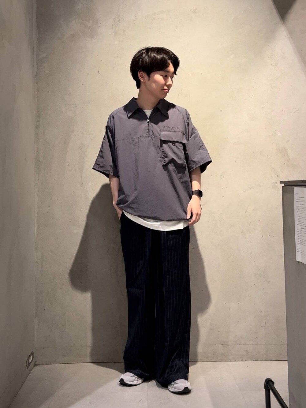 ブルー系のスラックス、ホワイト系のTシャツ/カットソー、グレー系のシャツ/ブラウスを着用したメンズの夏コーディネートの2枚目の写真