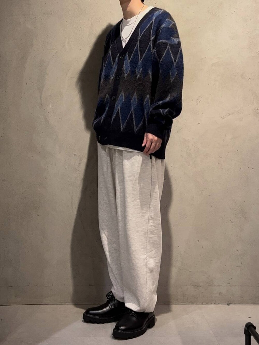 ブラック系のドレスシューズ、ブルー系のカーディガン/ボレロ、ホワイト系のTシャツ/カットソーを着用したメンズの秋コーディネートの2枚目の写真
