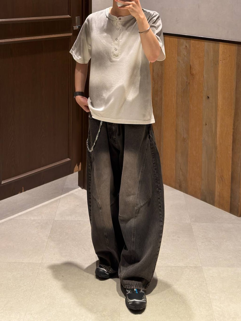 ブラック系のデニムパンツ、ホワイト系のTシャツ/カットソー、ブラック系のベルトを着用したメンズの夏コーディネートの2枚目の写真