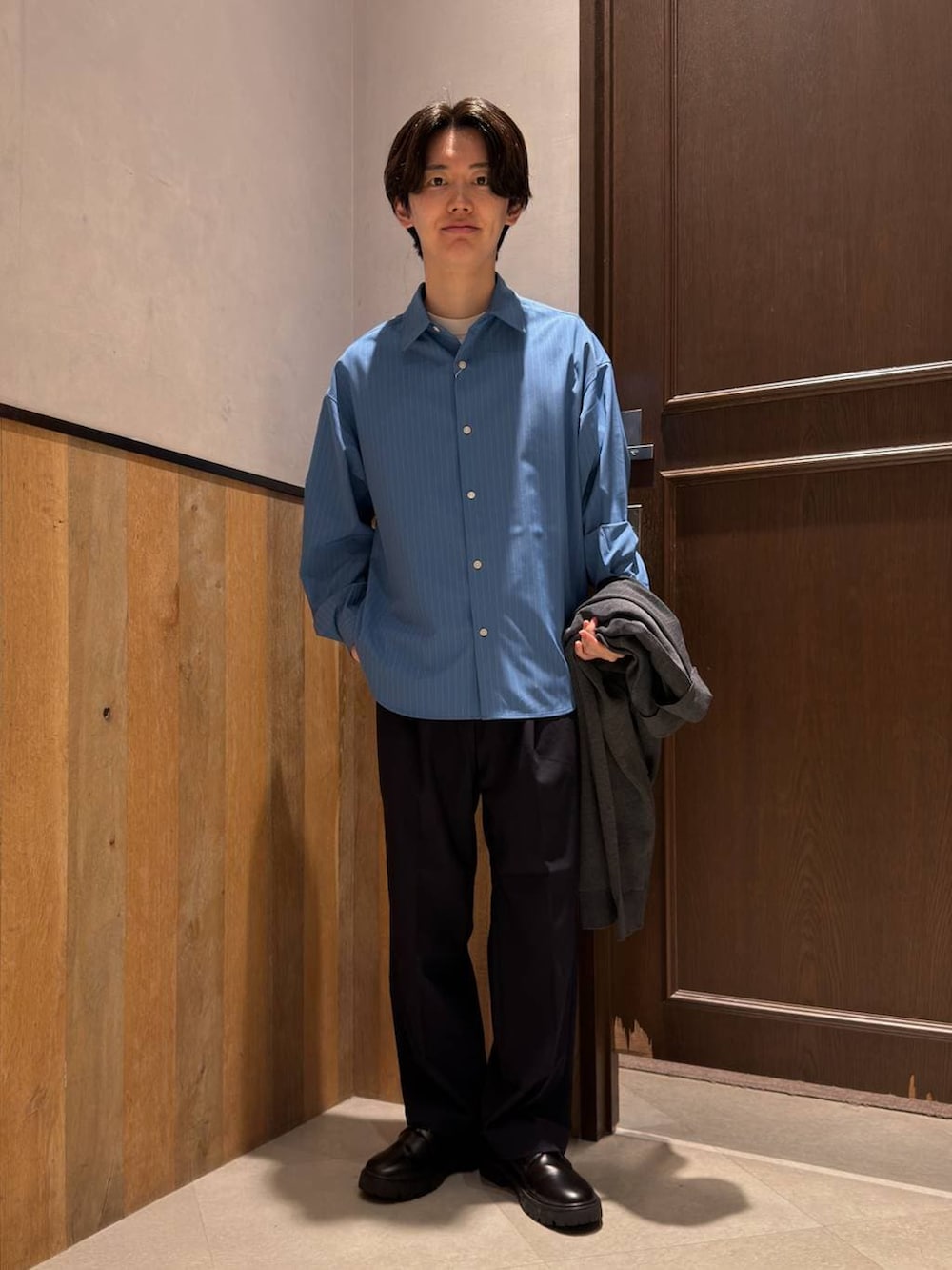 ブルー系のスラックス、ブラック系のドレスシューズ、ブルー系のシャツ/ブラウスを着用したメンズの春コーディネートの3枚目の写真